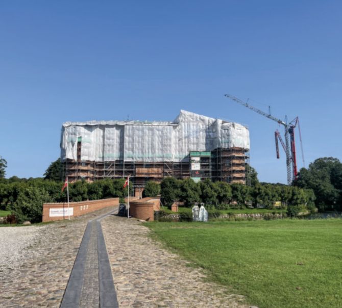 I forbindelse med udskiftningen af taget på Gammel Estrup blev hovedbygningen overdækket. Overdækningen af hele tagfladen har ikke tidligere været mulig, og det betød, at det var første gang siden opførelsen, at hele tagfladen stod åben på én gang. Håndværkere og arkitekt fik dermed indsigt i, nøjagtigt hvor mange steder det bærende bjælkelag var udfordret af råd, og derfor også nøjagtigt hvor udfordret og hvor ustabil tagfladen var. Gaven – i form af midler til tagets udskiftning – kom således i 11. time. Foto: Marie Kirstine Elkjær.